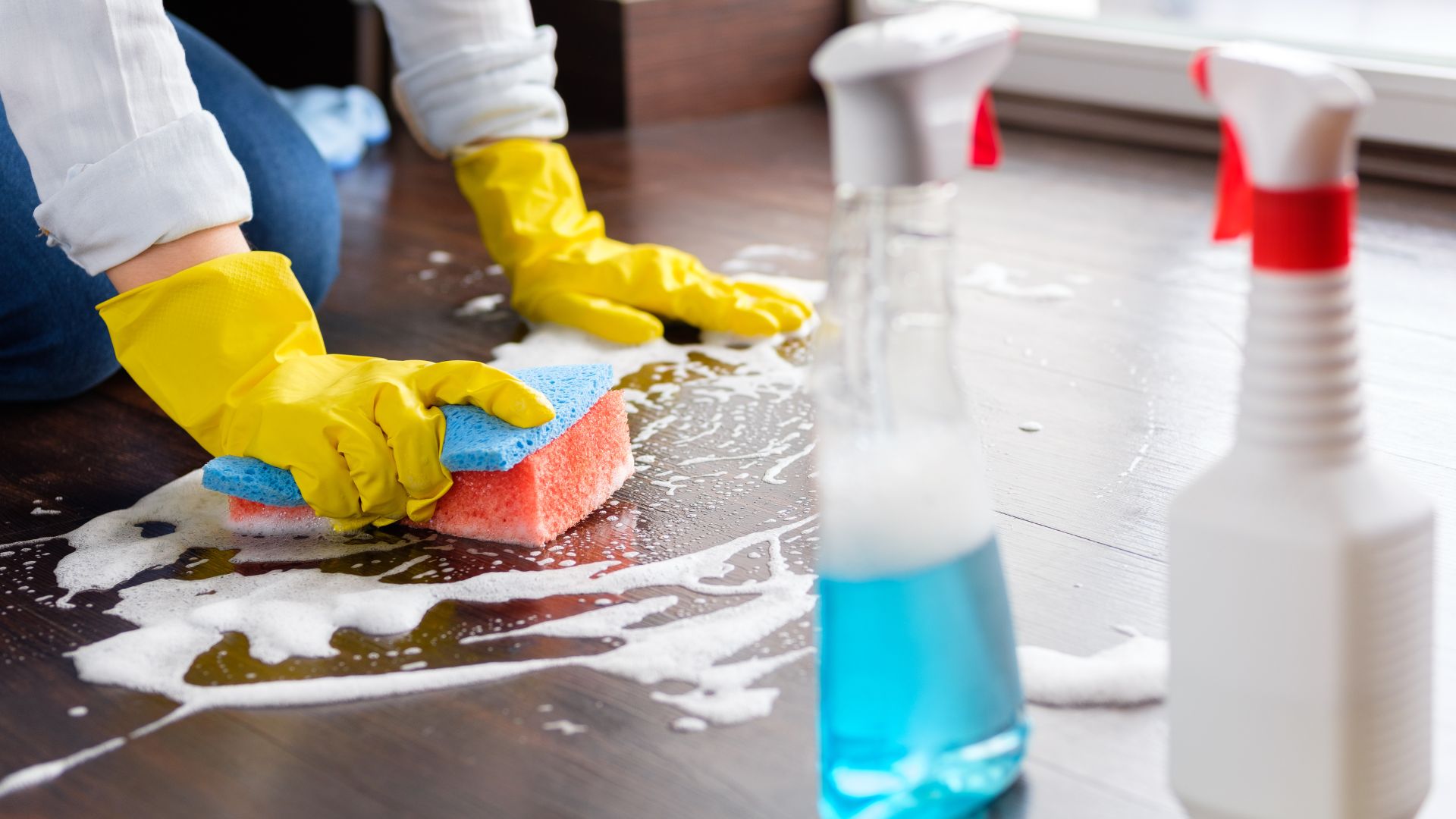 professional in yellow gloves cleaning floor with cleaners